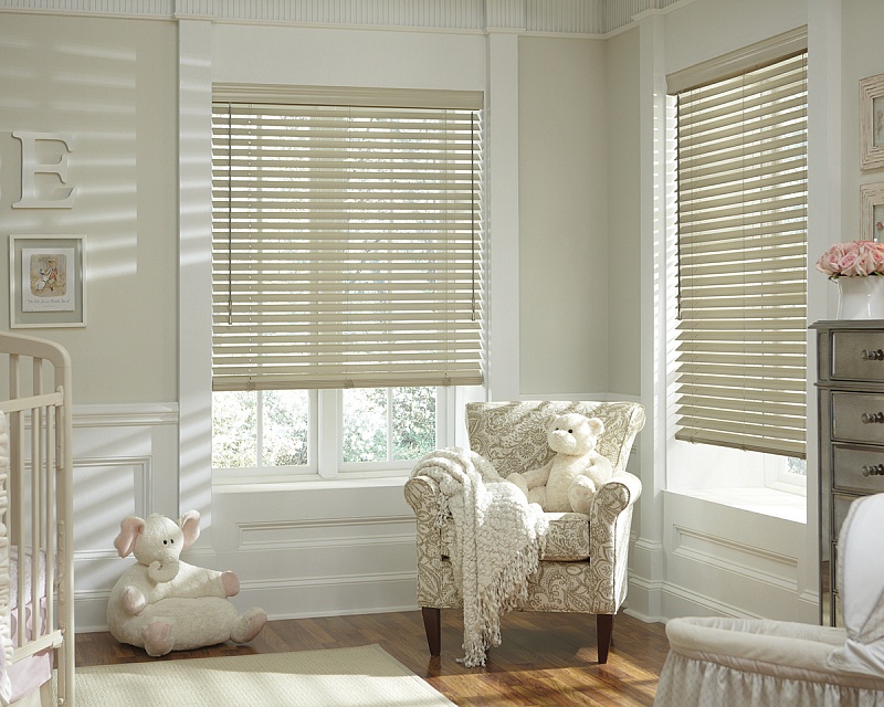 Woman pulling down fabric roller blinds in a modern Dubai living room